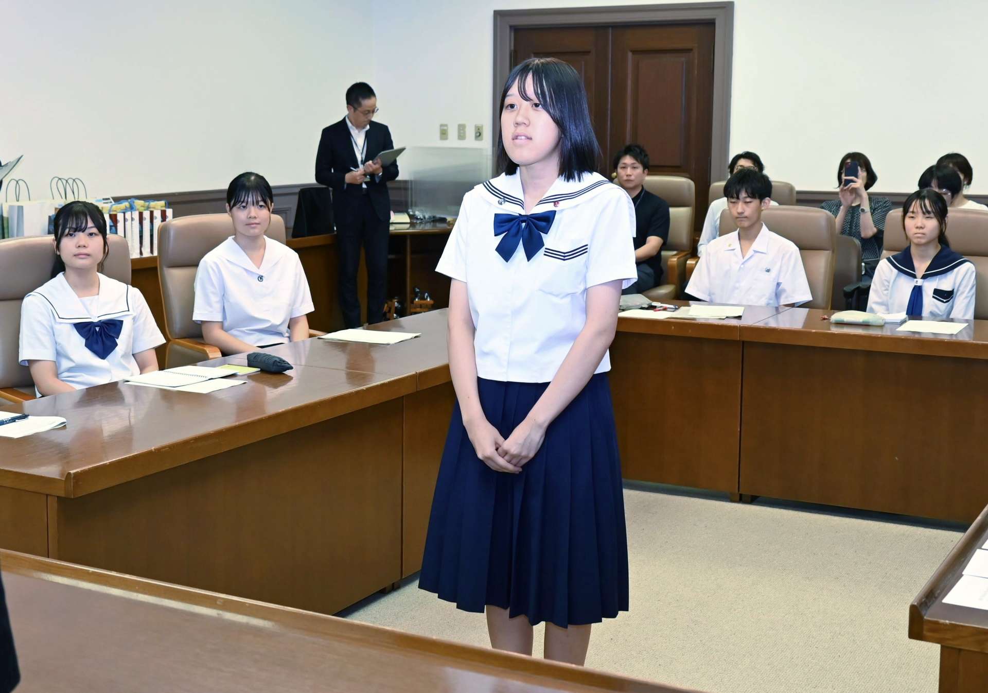 派遣生を代表して決意を述べる内田琴乃さん＝１４日、鹿児島市役所