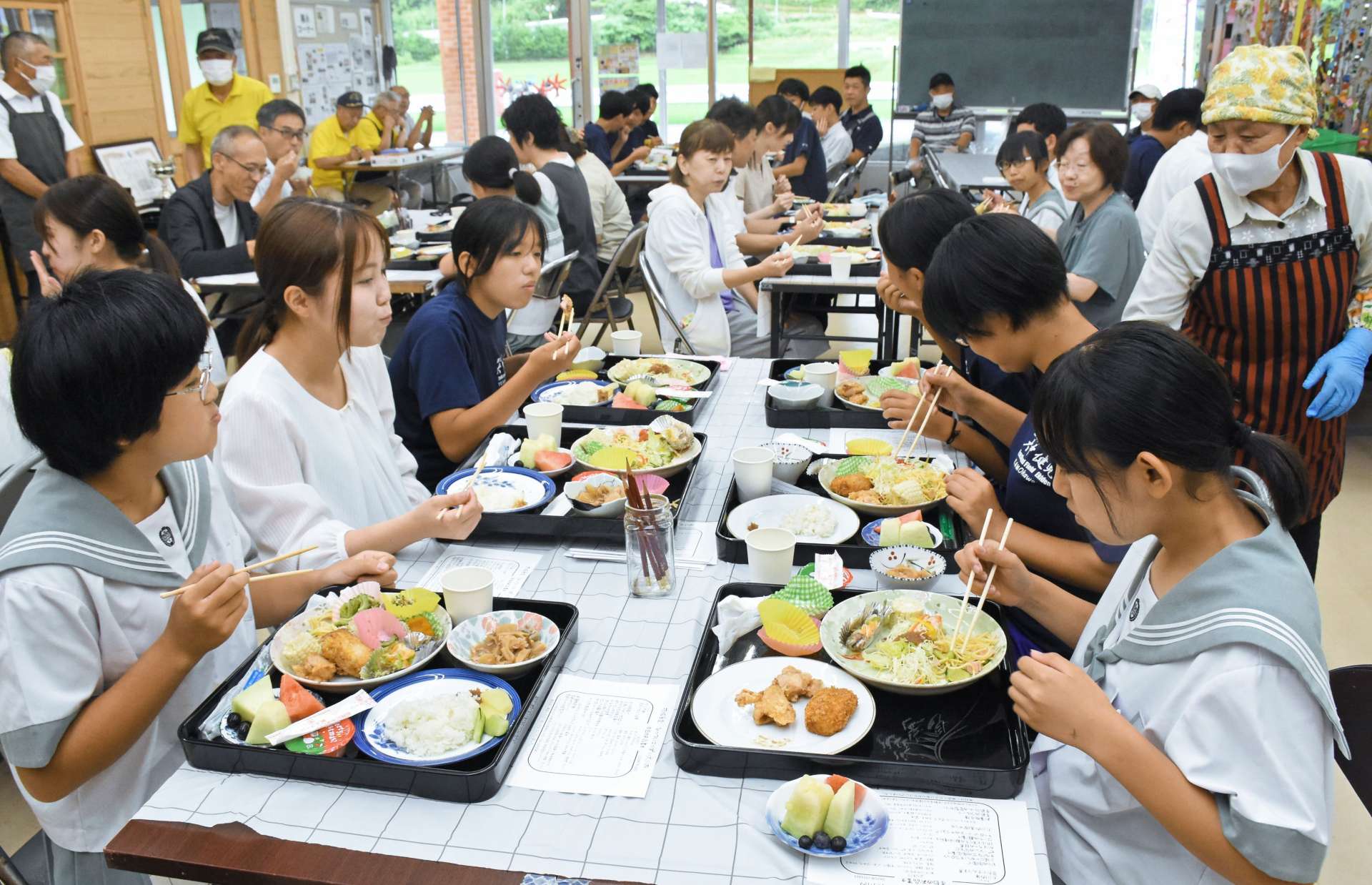 盛りだくさんの昼食を味わう中学生ら＝出水市上大川内