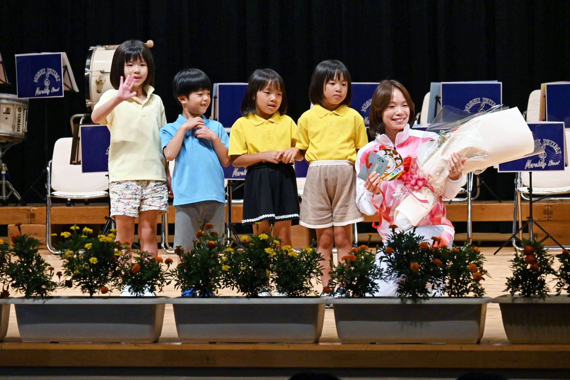 園児から花束やメダルを受け取り笑顔の一山麻緒選手（右）＝２３日、出水市文化町