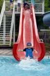プール開きでウオータースライダーを満喫する子ども＝湧水町の竹中池公園プール