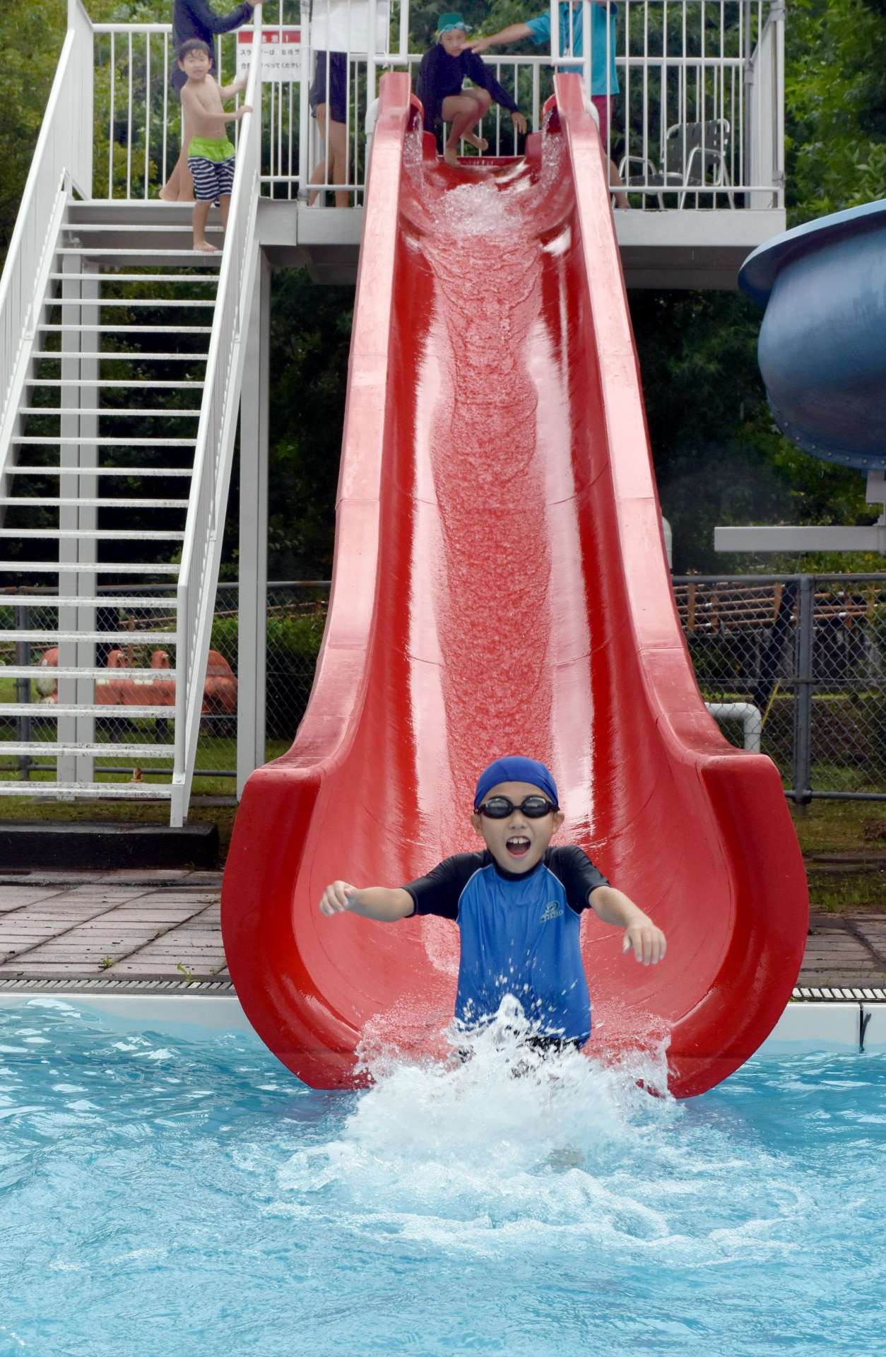 プール開きでウオータースライダーを満喫する子ども＝湧水町の竹中池公園プール