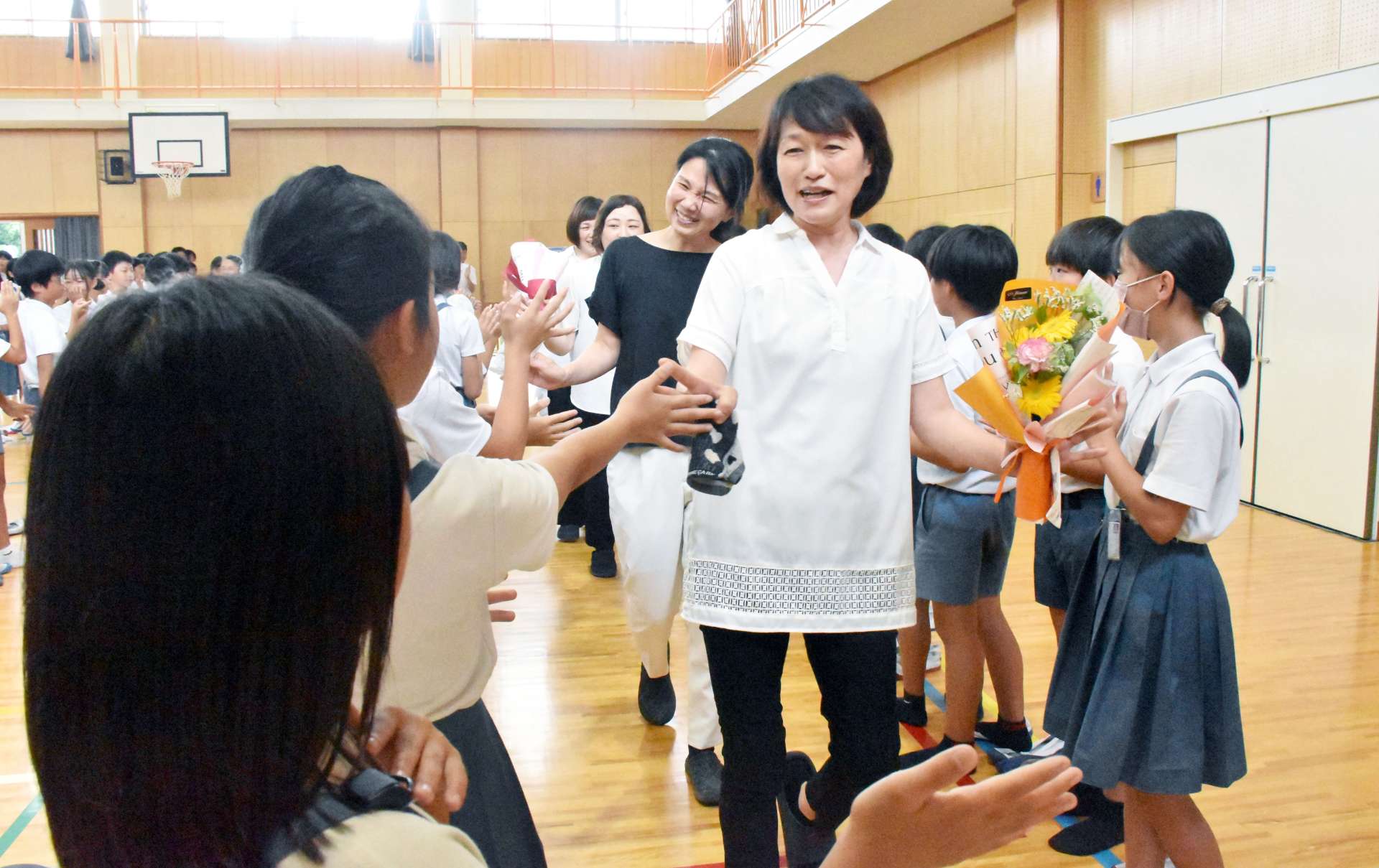 児童に見送られる調理員たち＝霧島市国分新町の国分北小学校