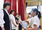 児童から花束を受け取る調理員たち＝霧島市国分新町の国分北小学校