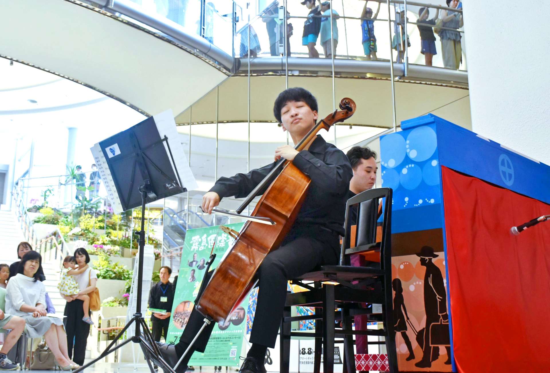 伸びやかな音色を奏でるチェリストの西田翔さんとピアニストの田中英明さん＝霧島市の鹿児島空港