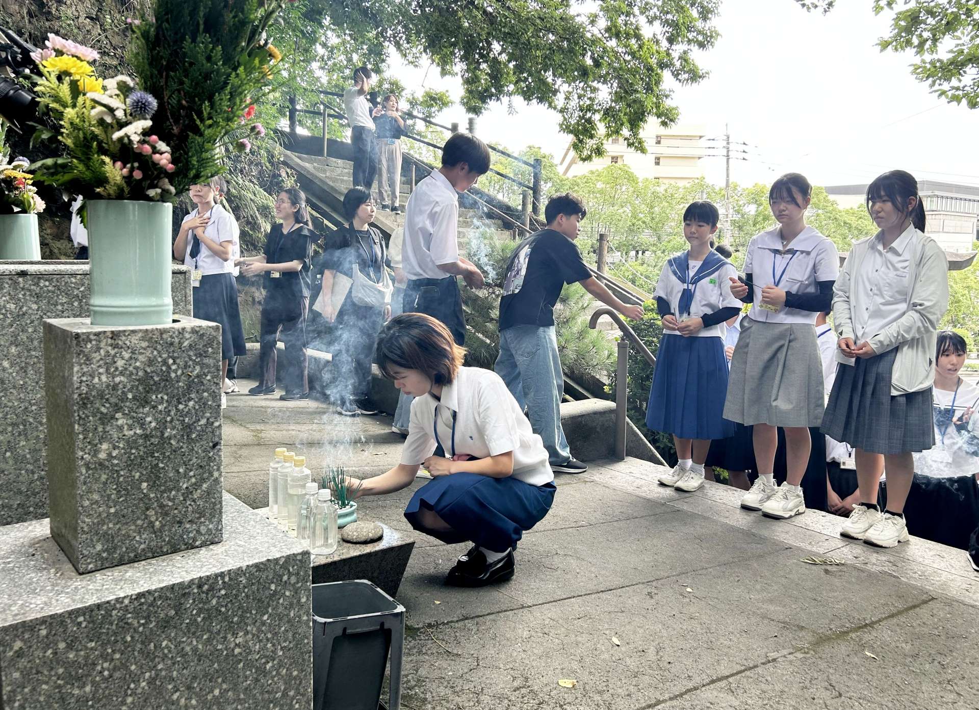 薩摩義士碑に線香を供えお参りする参加者ら＝２６日、鹿児島市城山町