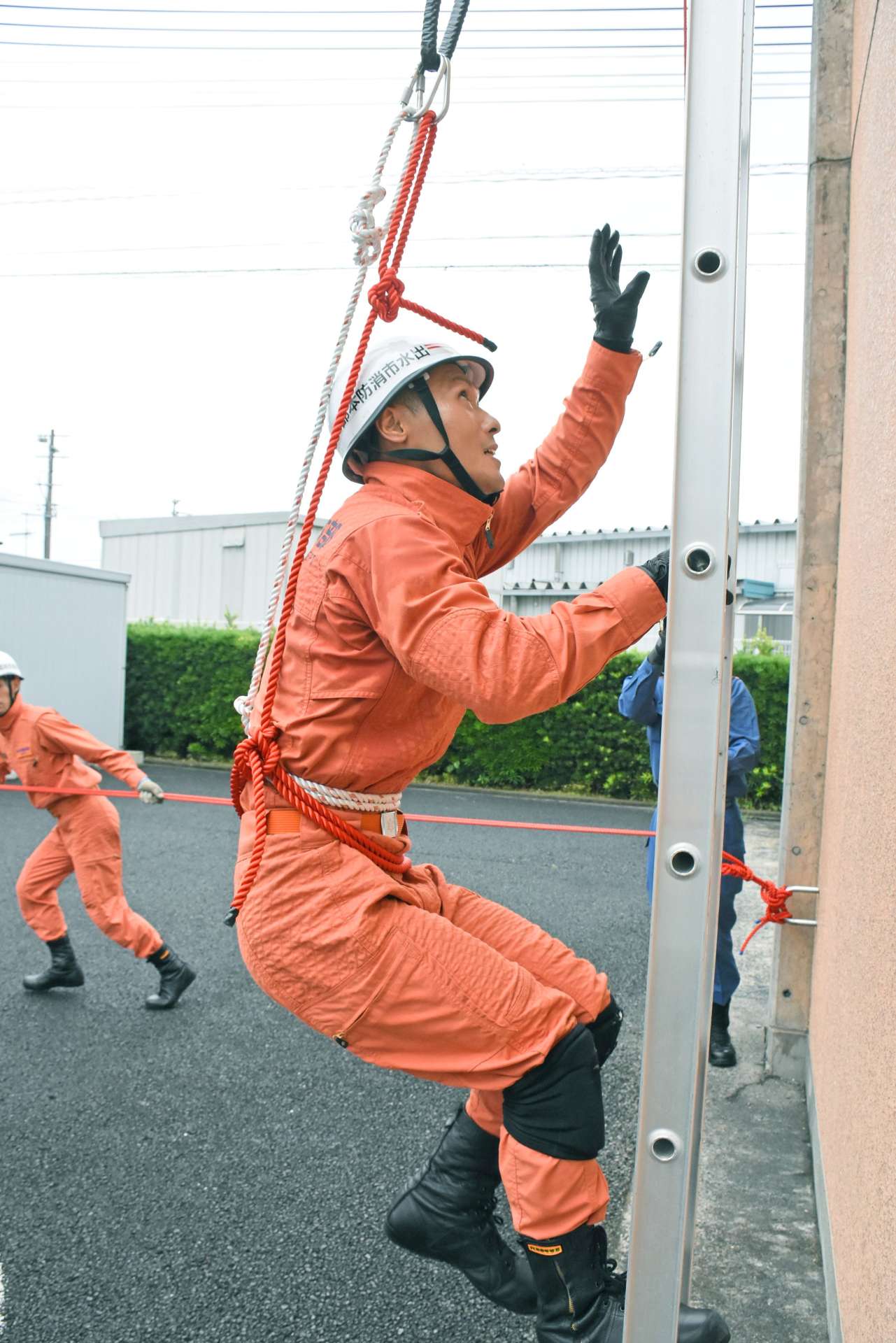 はしご登はんの訓練をする山田浩史さん＝出水市消防本部