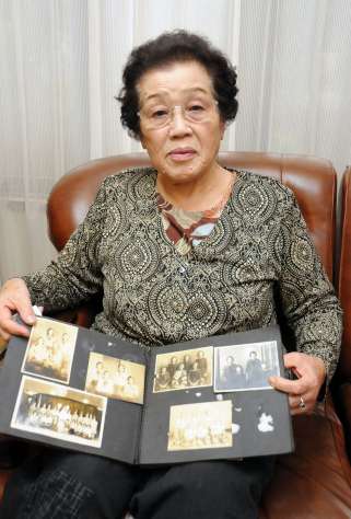 戦時中の写真を手に、当時を振り返る天野凉子さん＝志布志市志布志町安楽