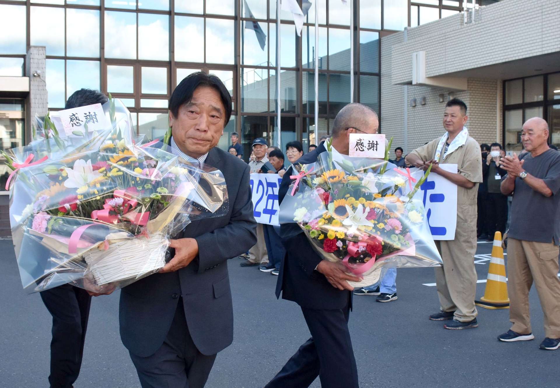 職員や市民に見送られて市役所を後にする五位塚剛市長ら＝３０日、曽於市末吉