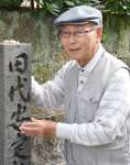 誕生地碑の前で田代安定の功績を語る名越護さん＝鹿児島市加治屋町