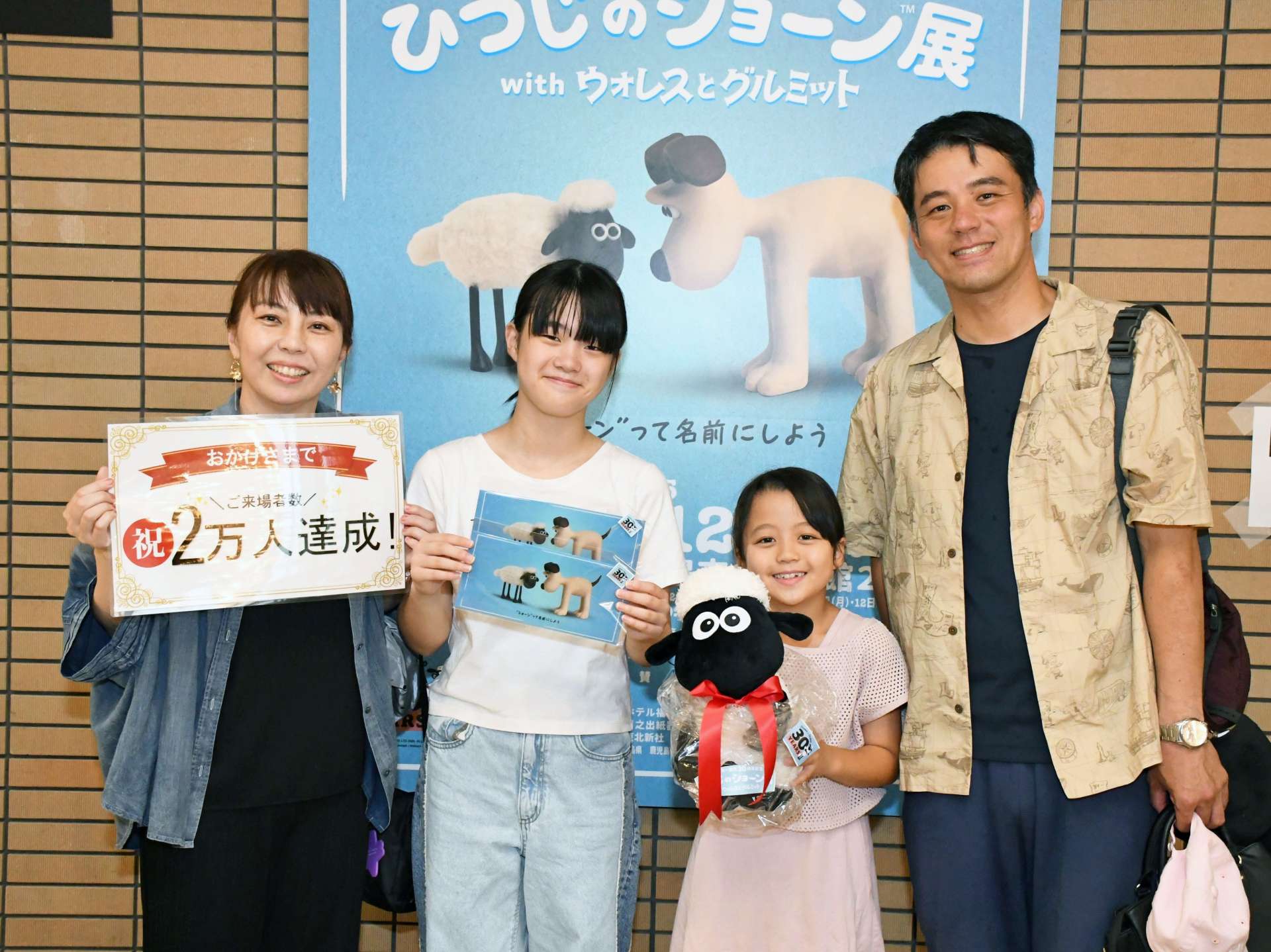 ２万人目の吉村さん家族＝５日、鹿児島市の黎明館