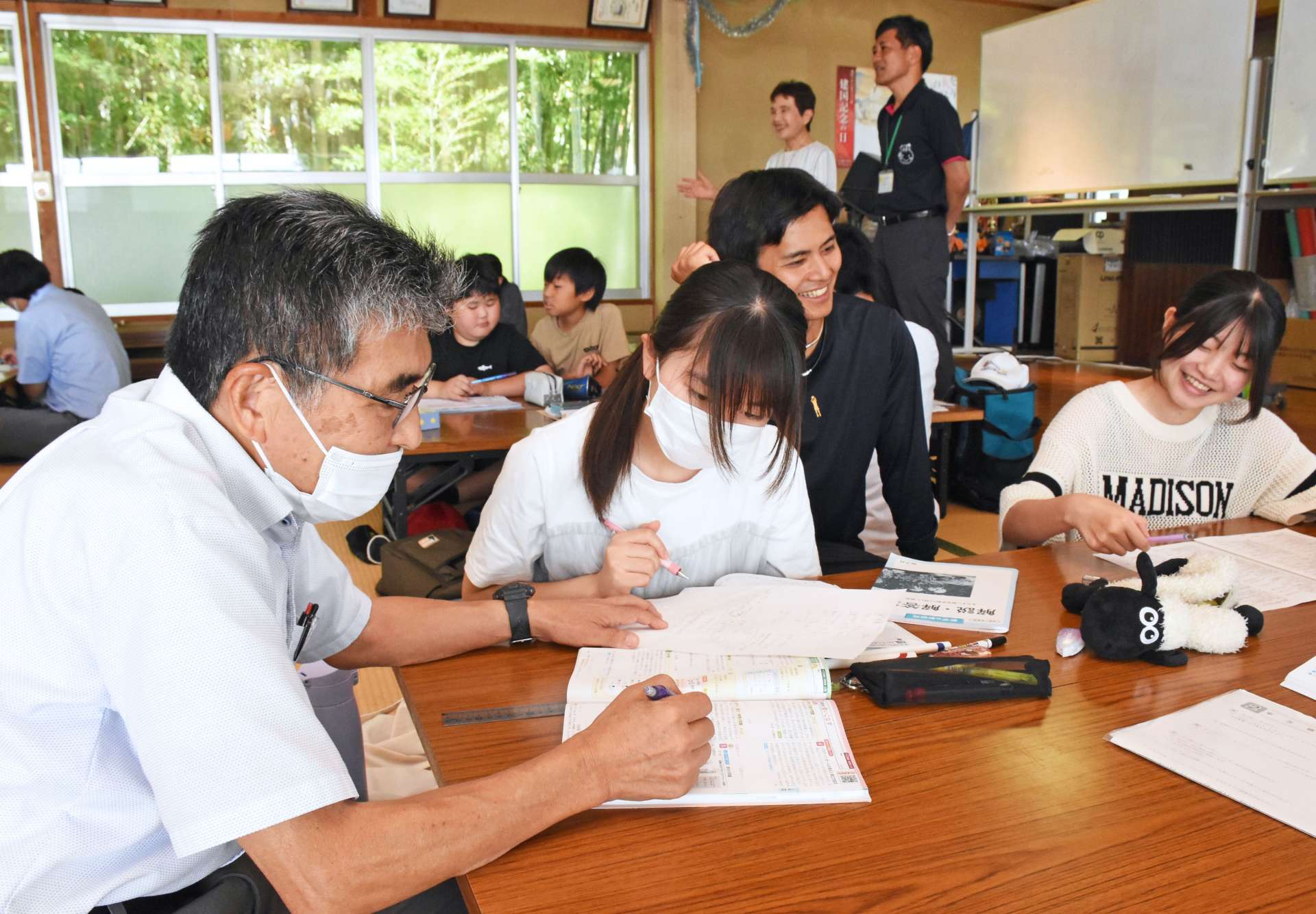 元教員（左）から数学を教わる中学生＝出水市高尾野町柴引