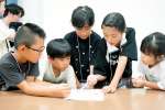 協力して謎を解く子どもたち＝７日、鹿児島市与次郎１丁目の鹿児島相互信用金庫本部