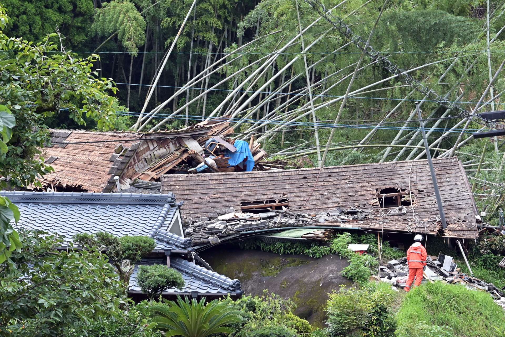 裏山が崩れ、倒壊した家屋＝８日午後３時半、姶良市蒲生町白男