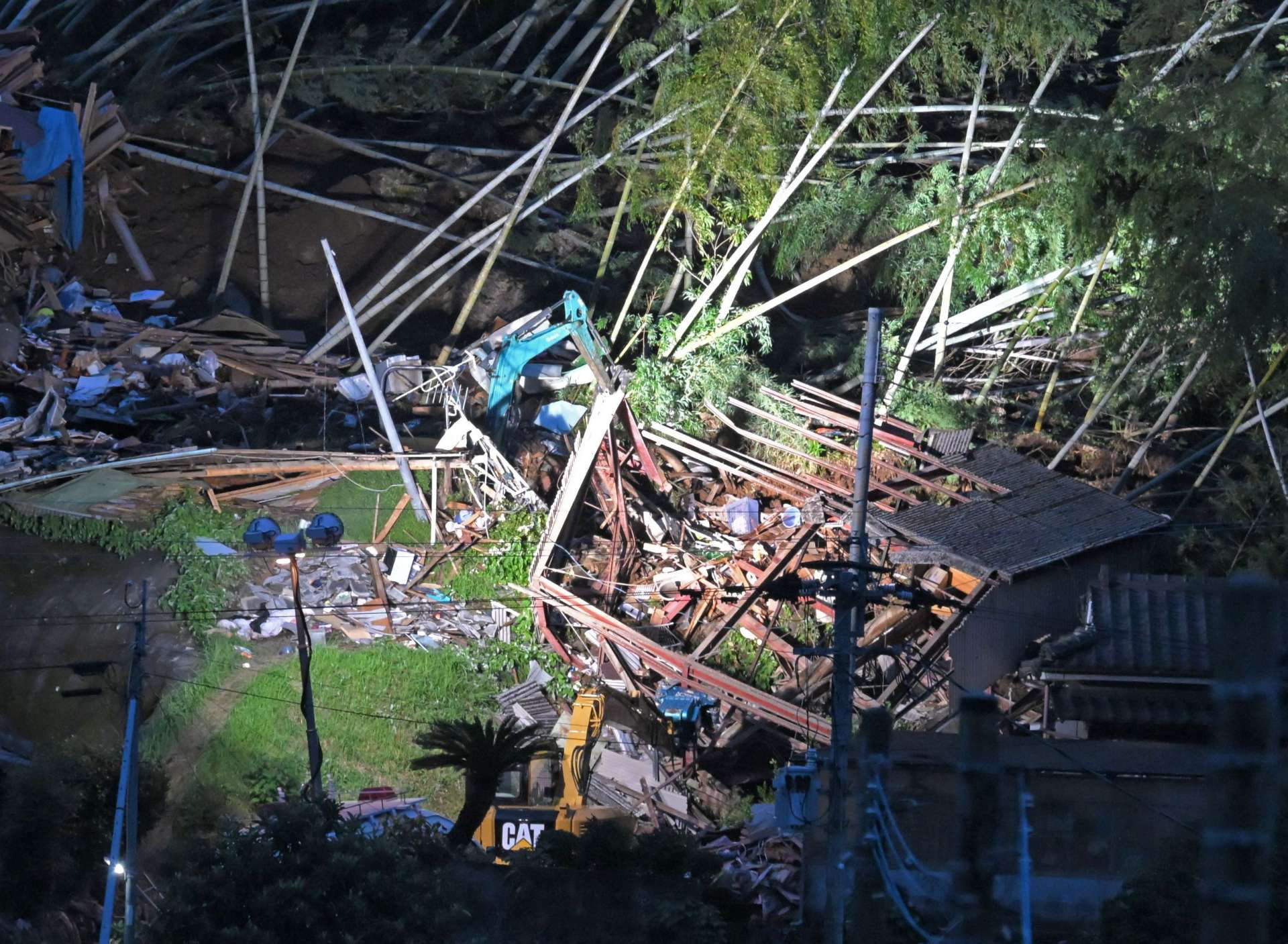 投光器を使い、捜索活動が続く家屋倒壊現場＝９日夜、姶良市蒲生町白男