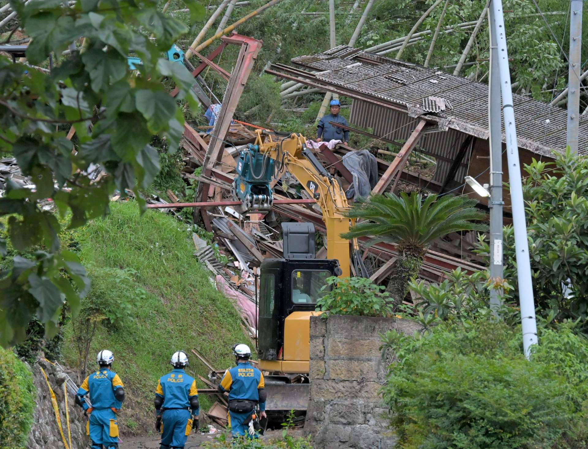 重機を使い捜索が続く家屋倒壊現場＝９日午後６時４３分、姶良市蒲生町白男