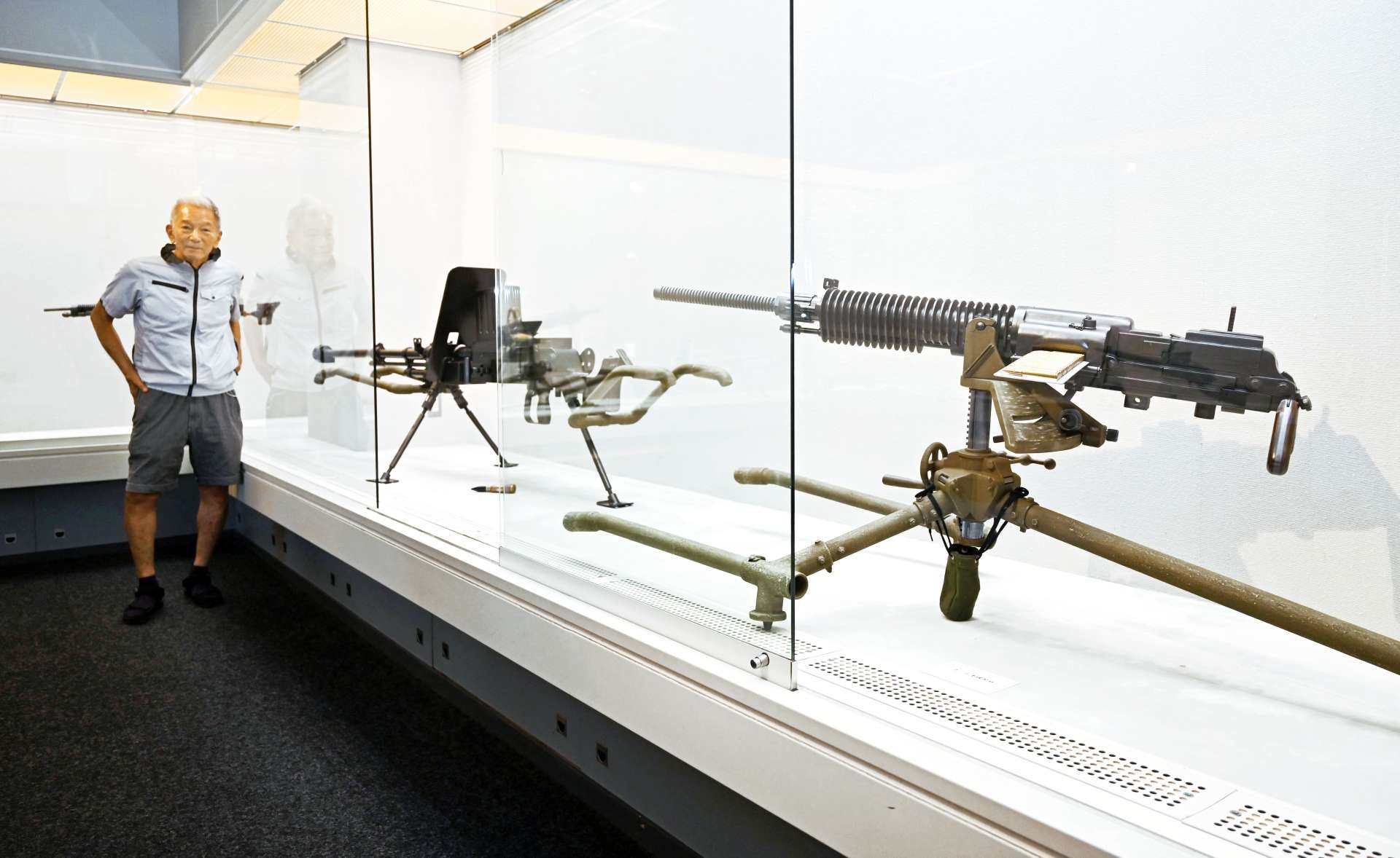 本物さながらの銃器模型で戦争のリアルを訴える池端信忠さん＝鹿児島市の谷山サザンホール