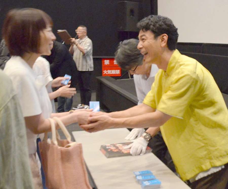 ２００人以上の観客一人一人に名刺を渡し、握手する妻夫木聡さん（右）＝１０日、鹿児島市の鹿児島ミッテ１０