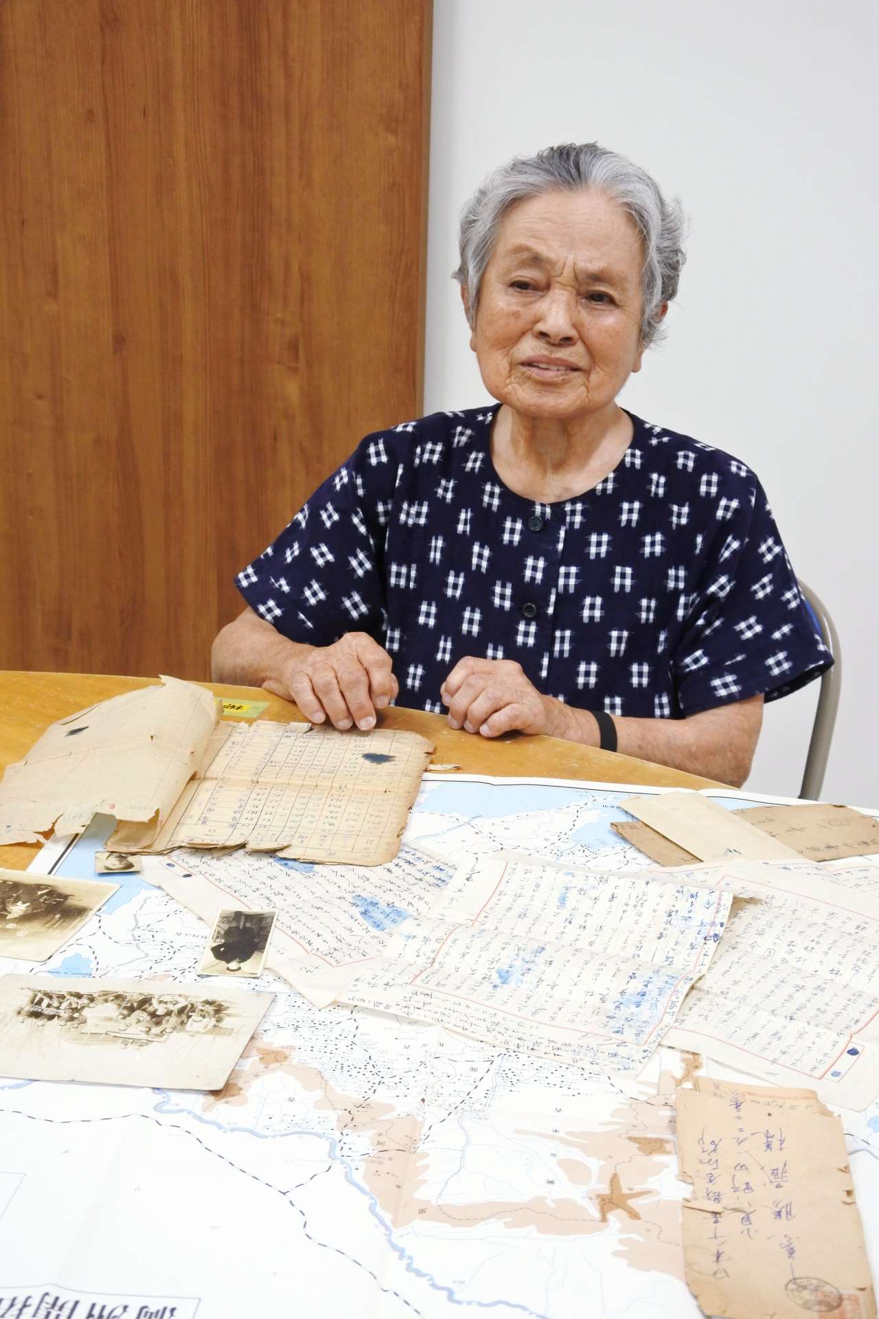 幼い弟と妹を失った大陸での生活を振り返り、涙をこらえる東八重子さん＝７月、霧島市隼人