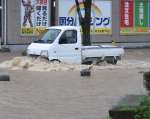 冠水した道路を進む車＝８日午前６時５５分ごろ、霧島市国分中央３丁目