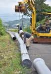仮設の導水管を取り付ける工事関係者＝１２日、姶良市中津野