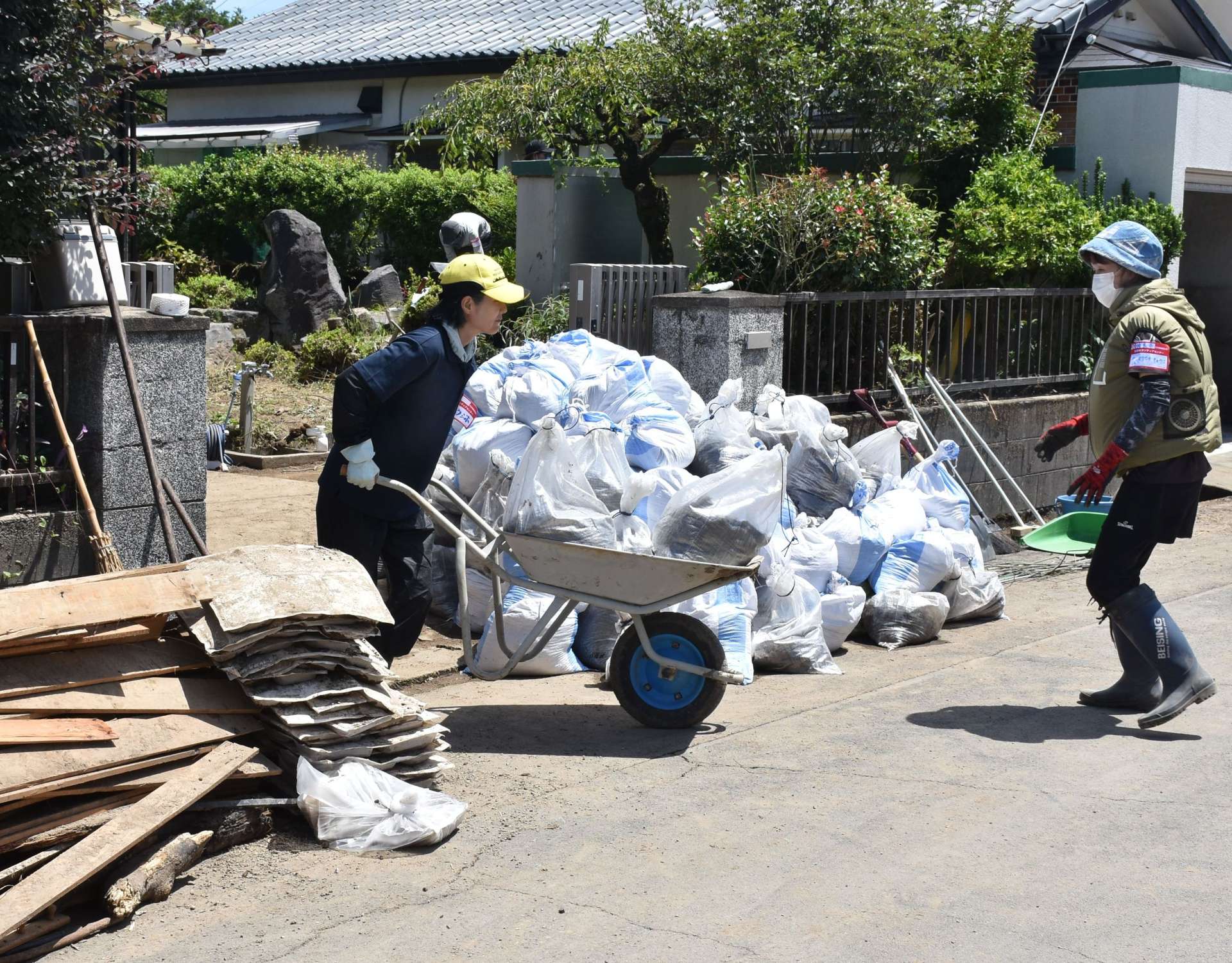 被災家屋で活動するボランティア＝１３日午後１時すぎ、姶良市平松