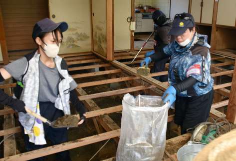 床下に流れ込んだ土砂を除去するボランティアら＝１３日午後１時１５分ごろ、姶良市平松