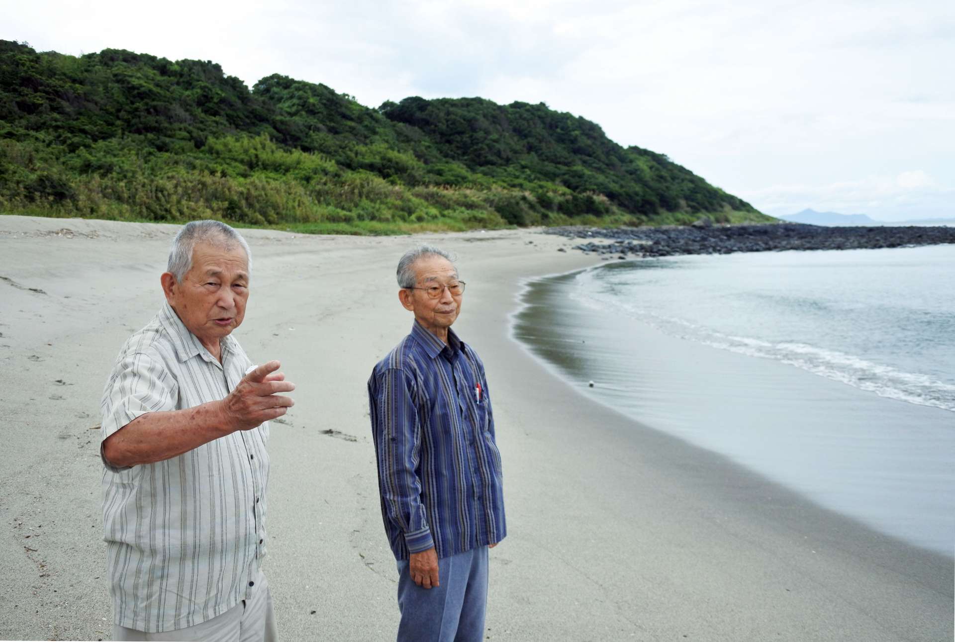 米軍を迎え撃つ準備が進められた吹上浜で、戦時中の記憶を語る中間啓行さん（左）と中山重雄さん＝７月、いちき串木野市