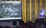戦時中の写真を示して思い出を語る澤俊文さん＝曽於市大隅の覚照寺