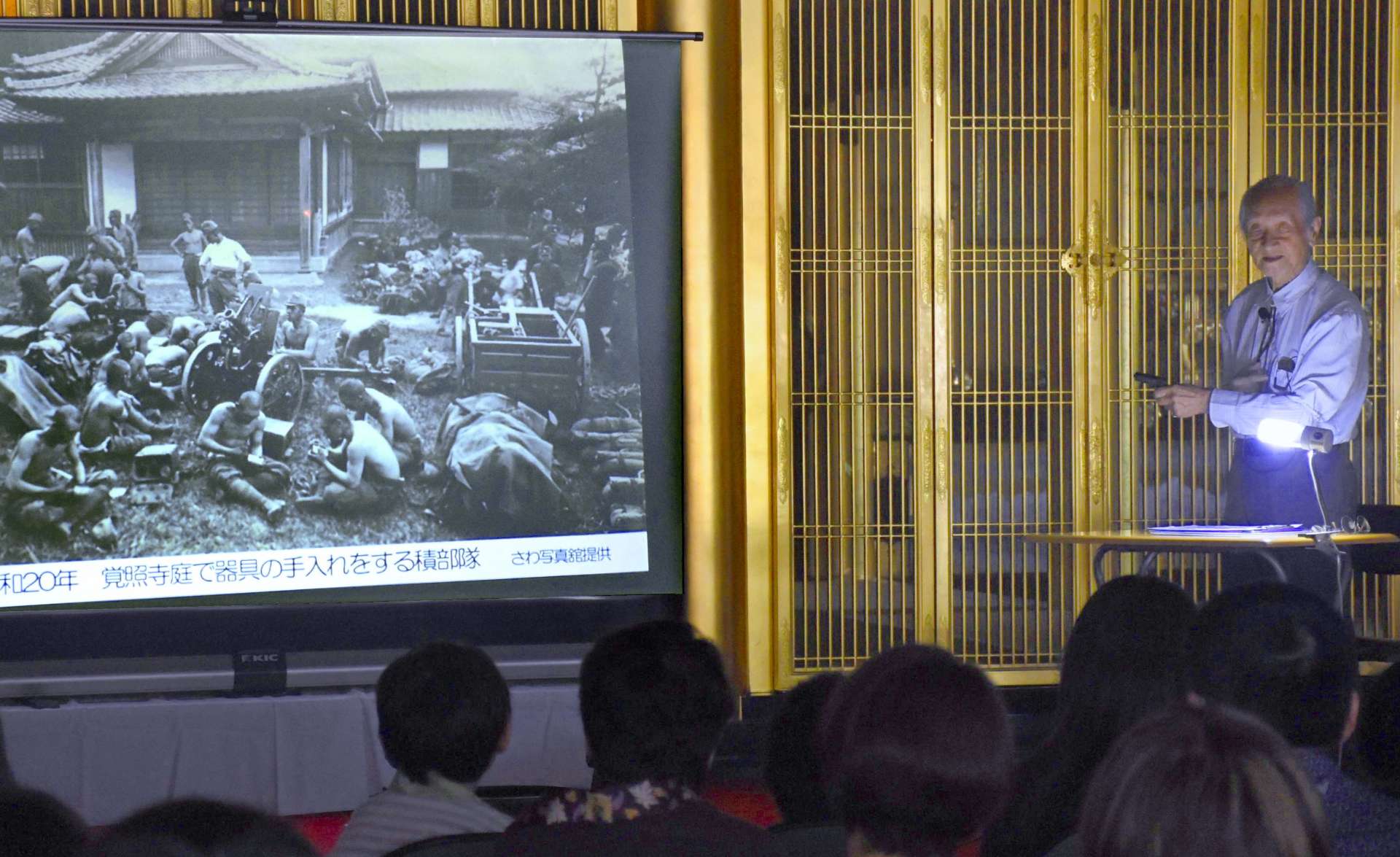 戦時中の写真を示して思い出を語る澤俊文さん＝曽於市大隅の覚照寺
