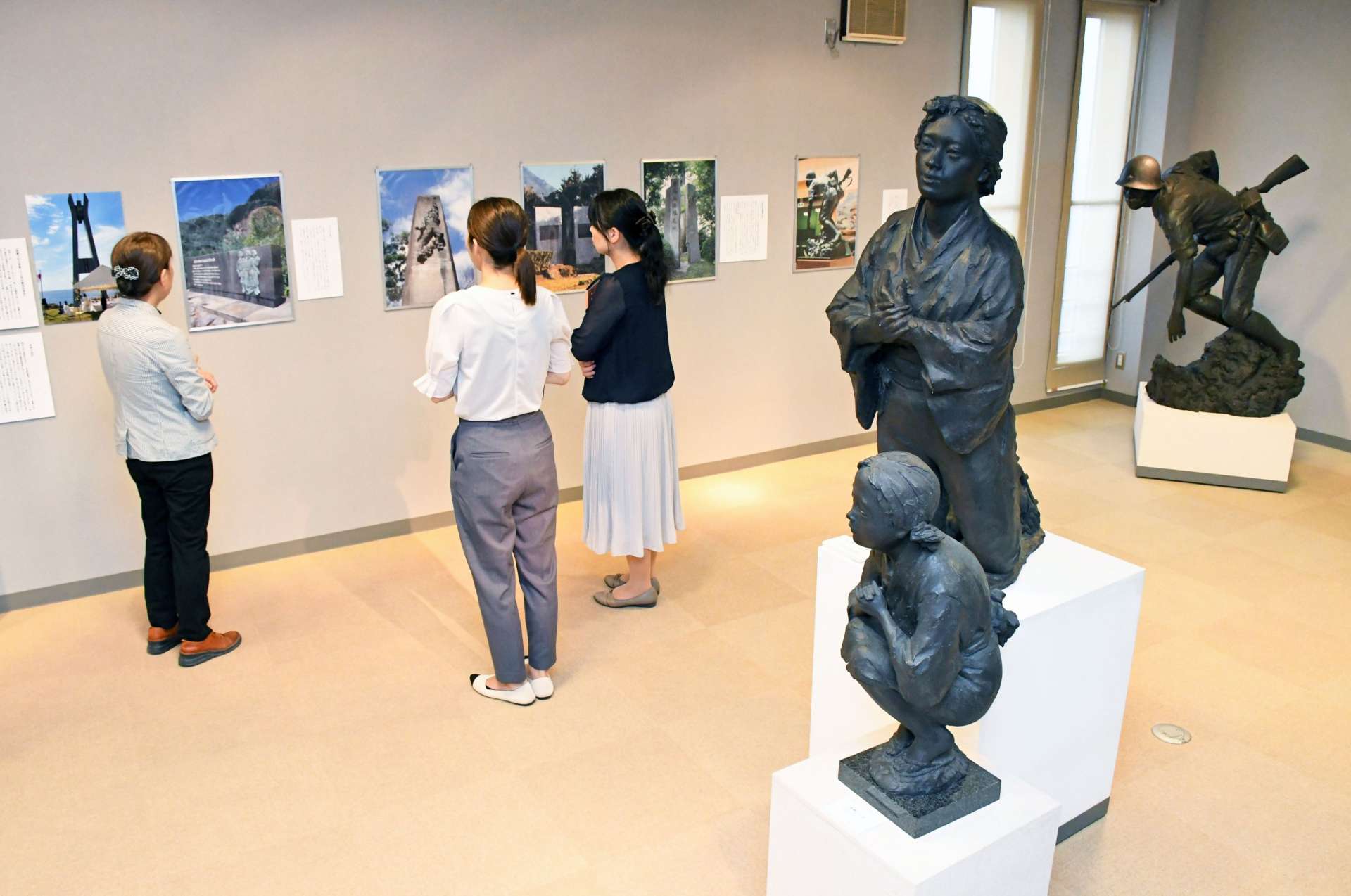 母子像の原型や慰霊碑の写真パネルが並ぶ会場＝鹿児島市の中村晋也美術館