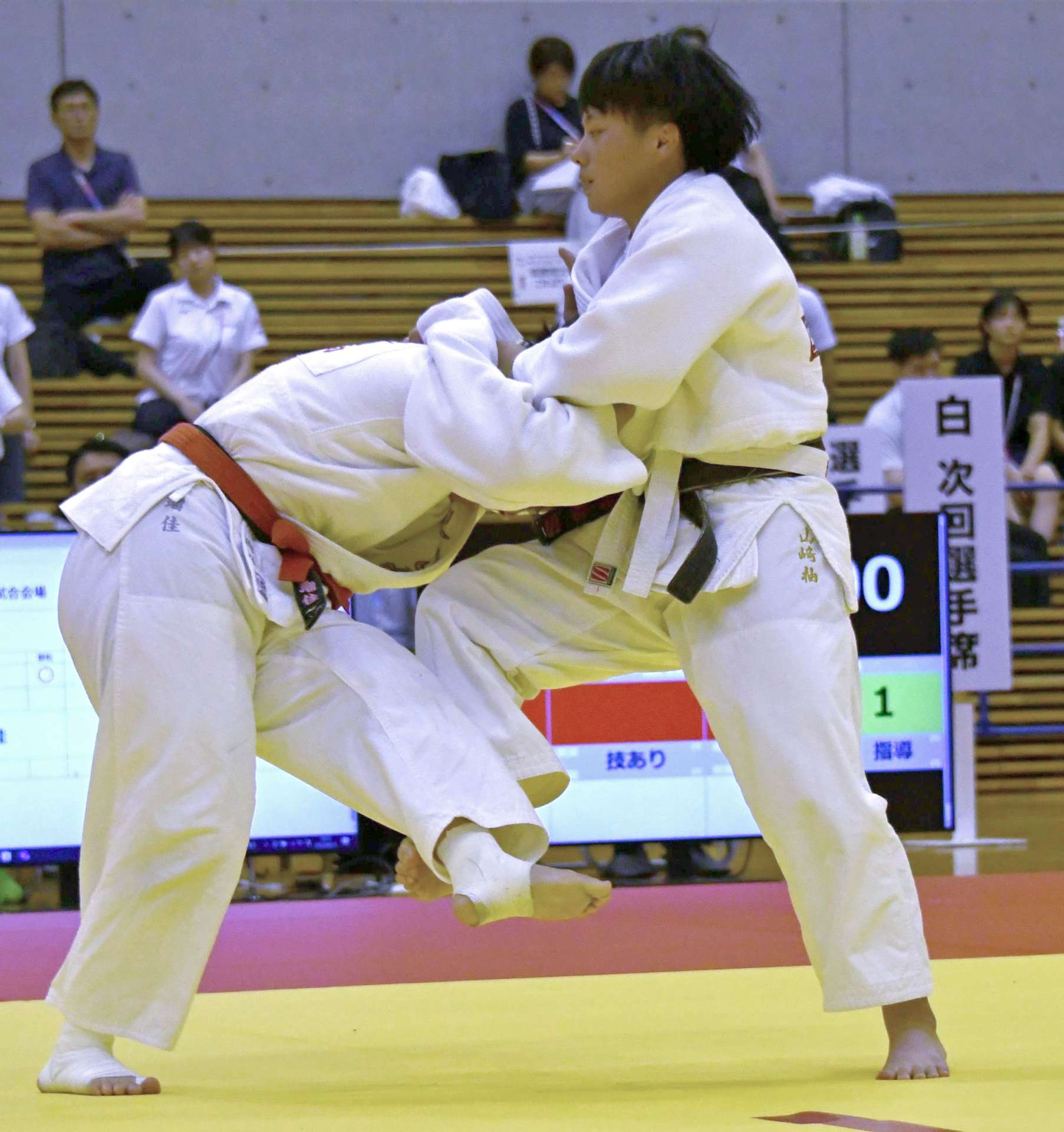 女子団体１回戦、小外刈りを仕掛ける国分中央の大将・山崎（右）＝ジップアリーナ岡山