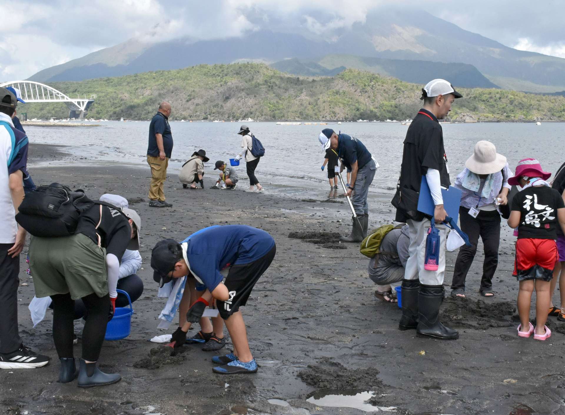海岸の砂を掘って生き物を探す子どもたち＝垂水市牛根麓