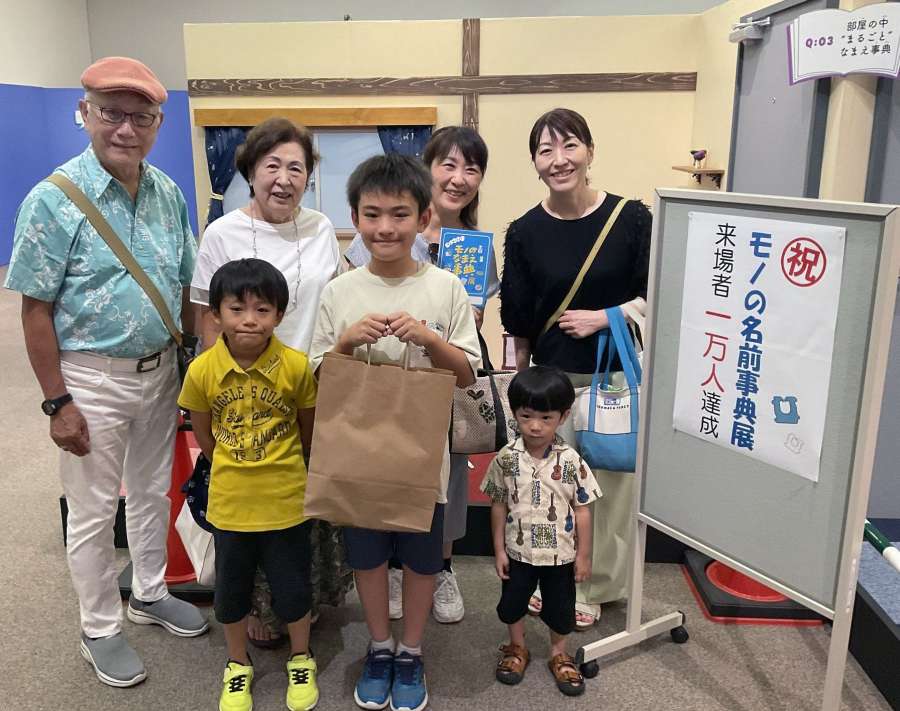 「モノのなまえ事典展」の１万人目となった浦牛原悠さん（前列中央）＝１３日、鹿児島市のかごしまメルヘン館