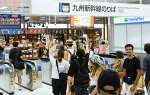 〈最後まで手を振り〉改札口前で別れを惜しむＵターン客＝１６日正午すぎ、鹿児島市のＪＲ鹿児島中央駅