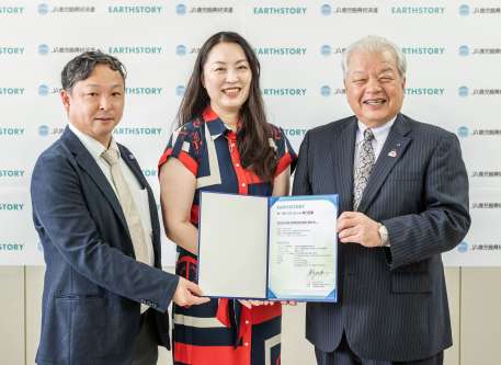 肉用牛生産で出る温室効果ガス（ＧＨＧ）排出量削減のボランタリークレジット発行証書を披露するＪＡ鹿児島県経済連の柚木弘文会長（右）（同連提供）