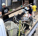 被災した建物から廃棄物を運び出す参加者ら＝６月２９日、薩摩川内市里