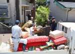 被災した建物から廃棄物を運び出す参加者ら＝６月２９日、薩摩川内市里