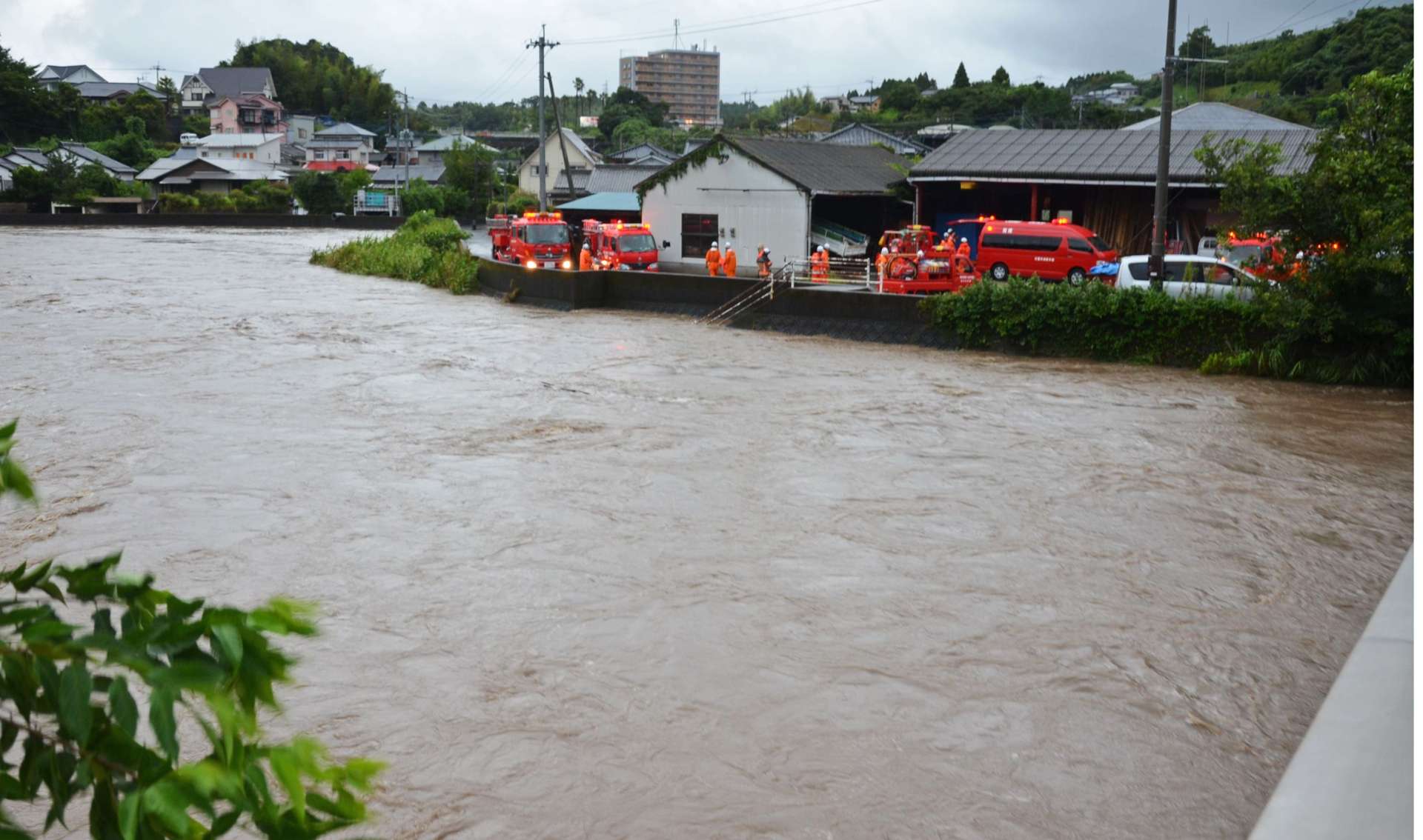 一時、氾濫危険水位を超える３．７０メートルを記録した神之川。消防が排水作業に当たる＝２１日午後５時４３分、日置市伊集院