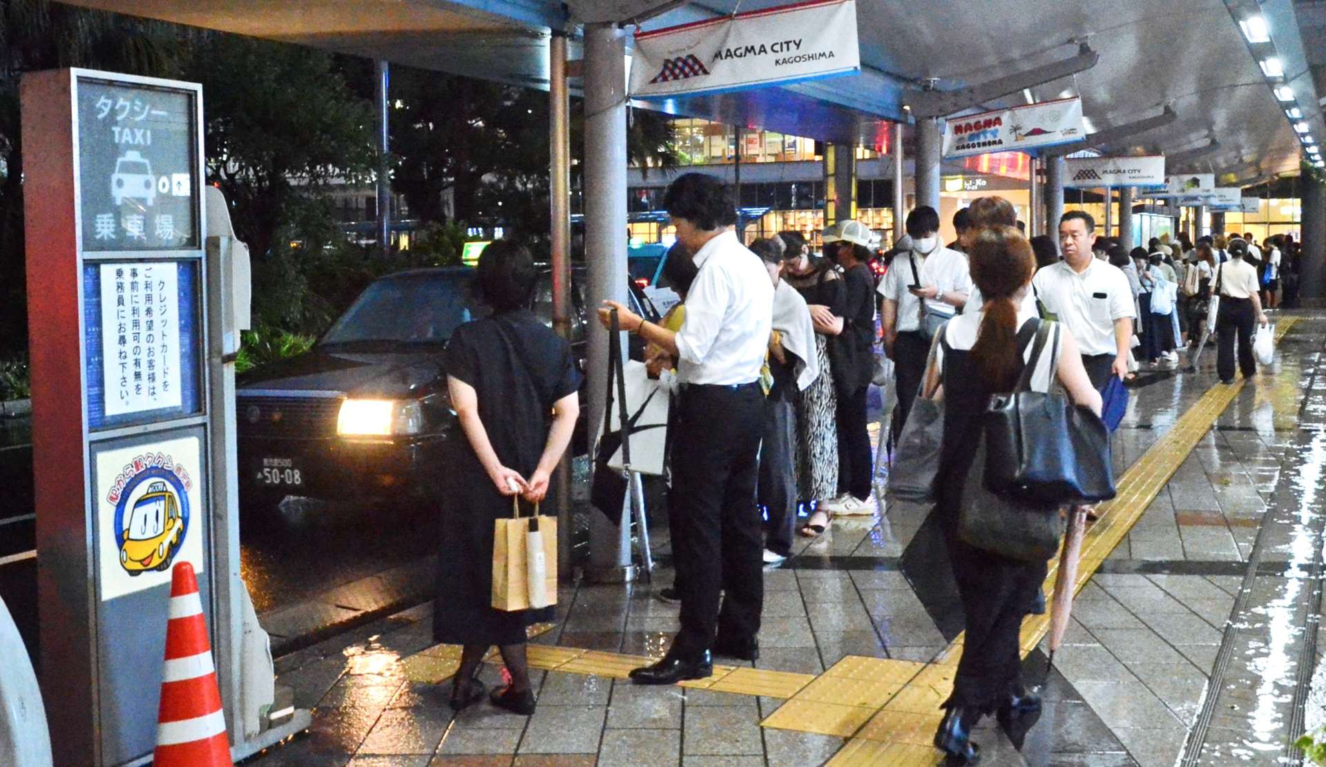 タクシーを待つ人で混雑する乗車場＝２１日午後７時すぎ、鹿児島市の鹿児島中央駅前