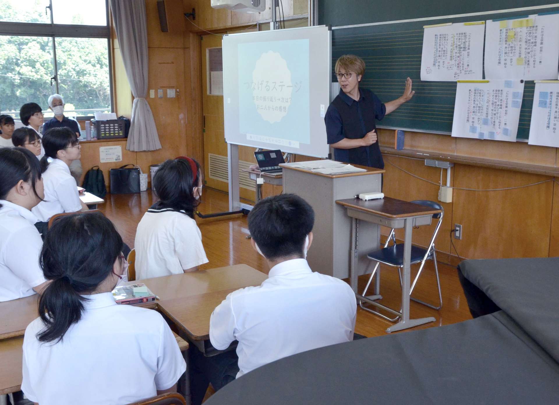 「たかはる学園」の校歌作りについて参加者の児童生徒に説明する大野勇太さん（中央）＝宮崎県高原町西麓の高原中学校