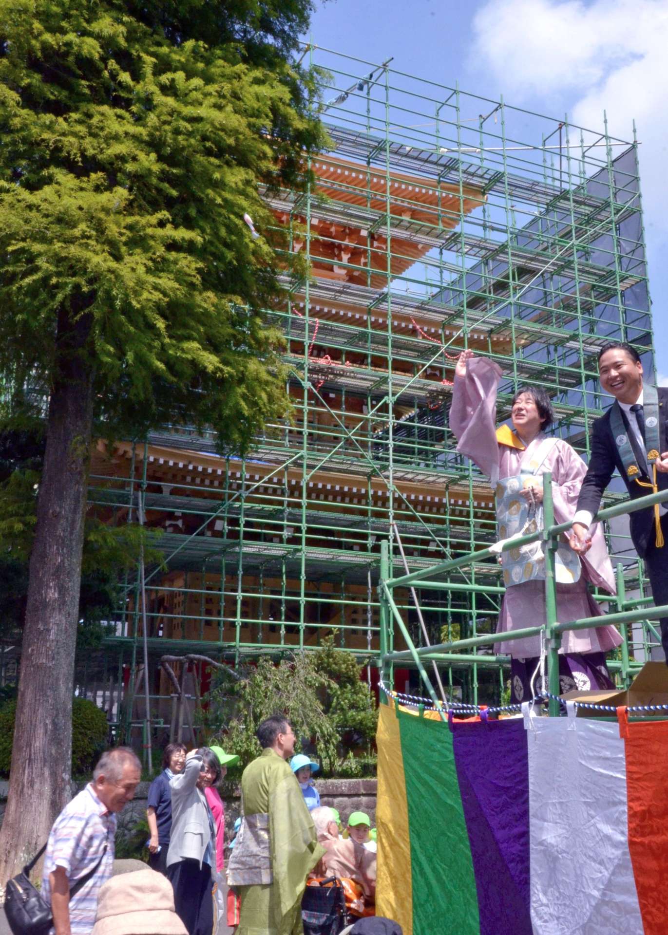 〈関連〉三重塔の上棟を祝い餅まきをする攝護寺の佐々木慈舟住職（右から２人目）ら＝都城市牟田町