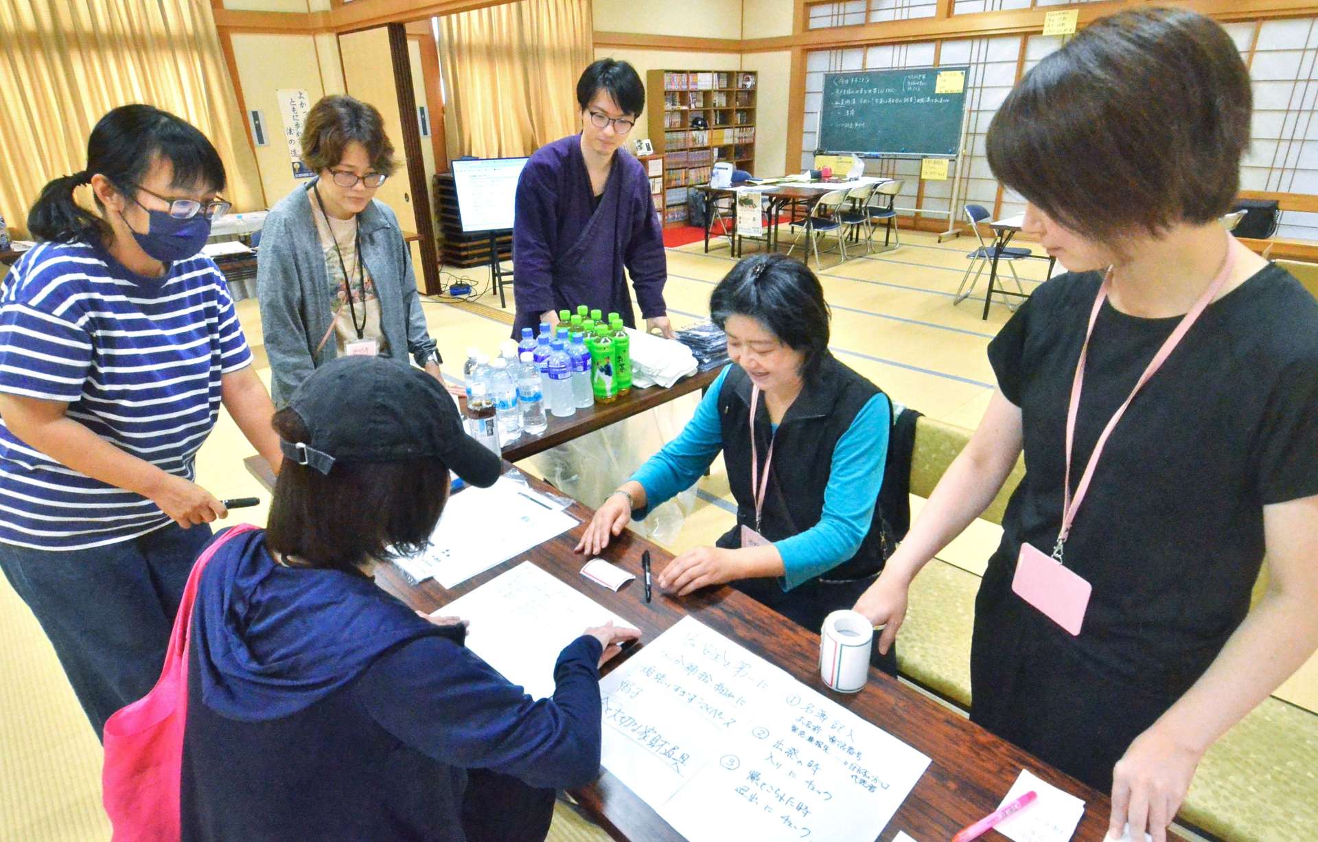 ボランティアの受け付けをするスタッフ＝２４日午前、鹿児島市和田１丁目の妙行寺