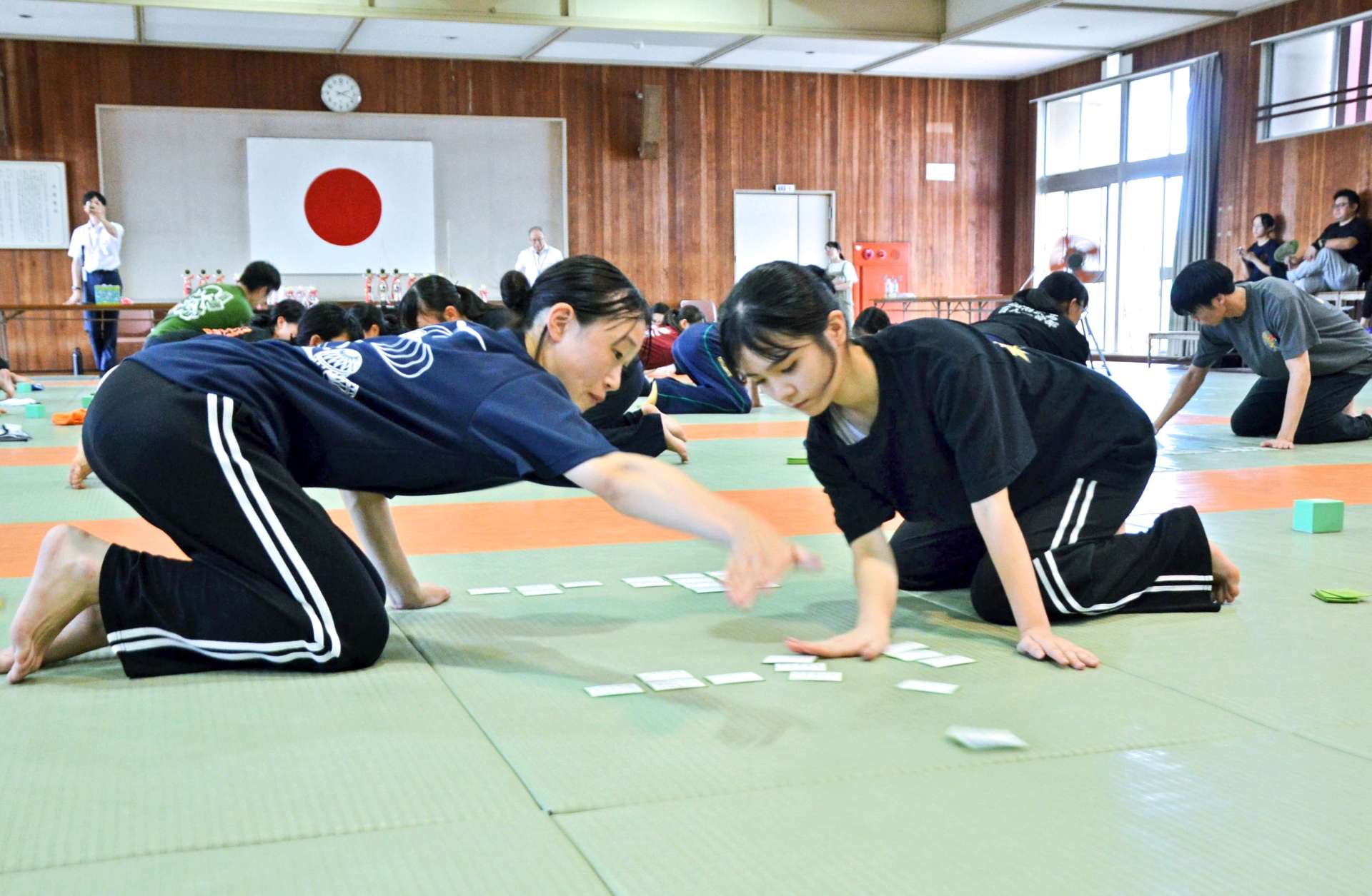 真剣な表情で札を取り合う出場選手＝１７日、鹿児島市の県武道館