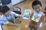 ＡＩで作った絵本の完成を喜ぶ子どもたち＝錦江町の地域活性化センター神川