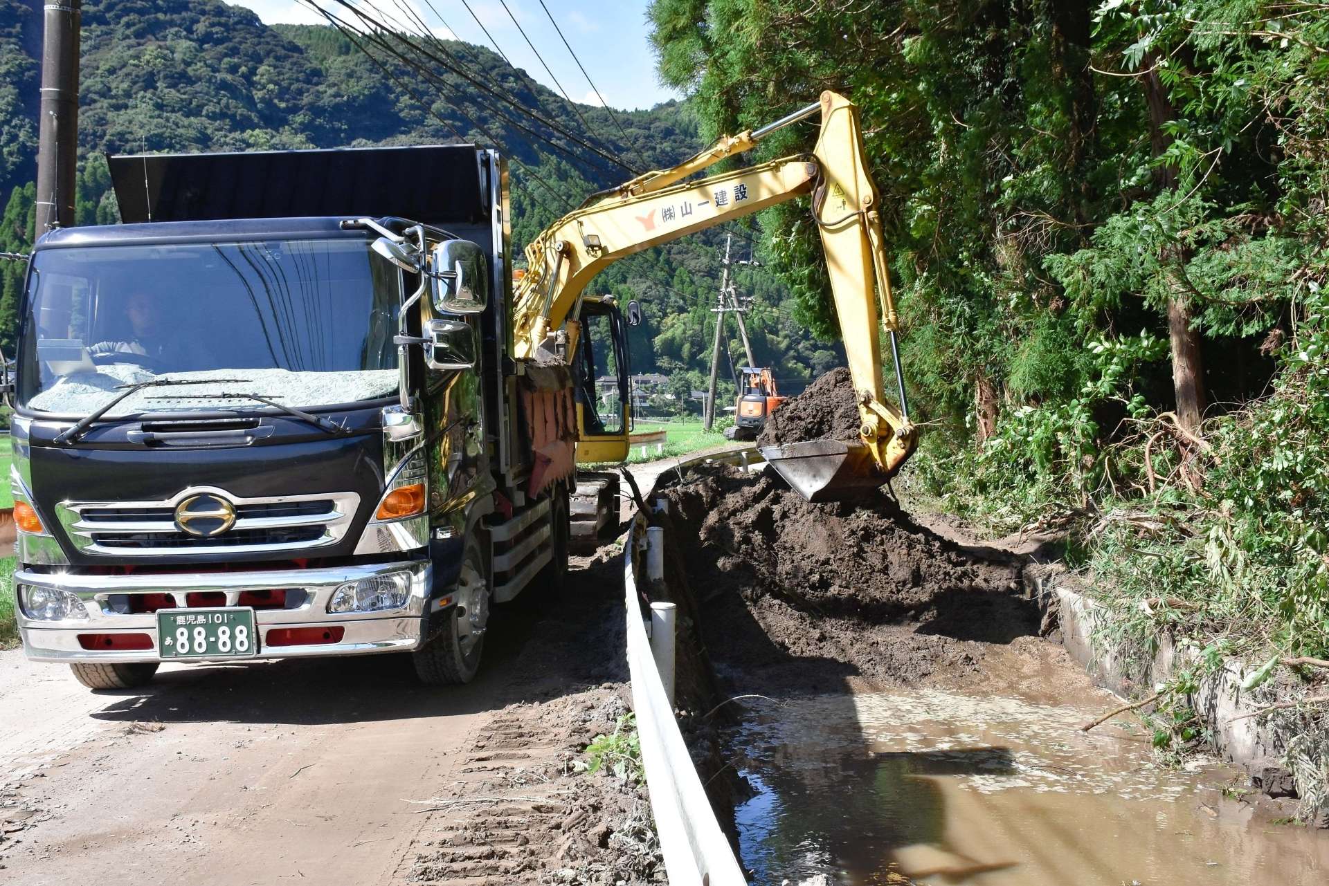 農業用水路に流れ込んだ土砂の撤去作業＝１３日、霧島市隼人町松永