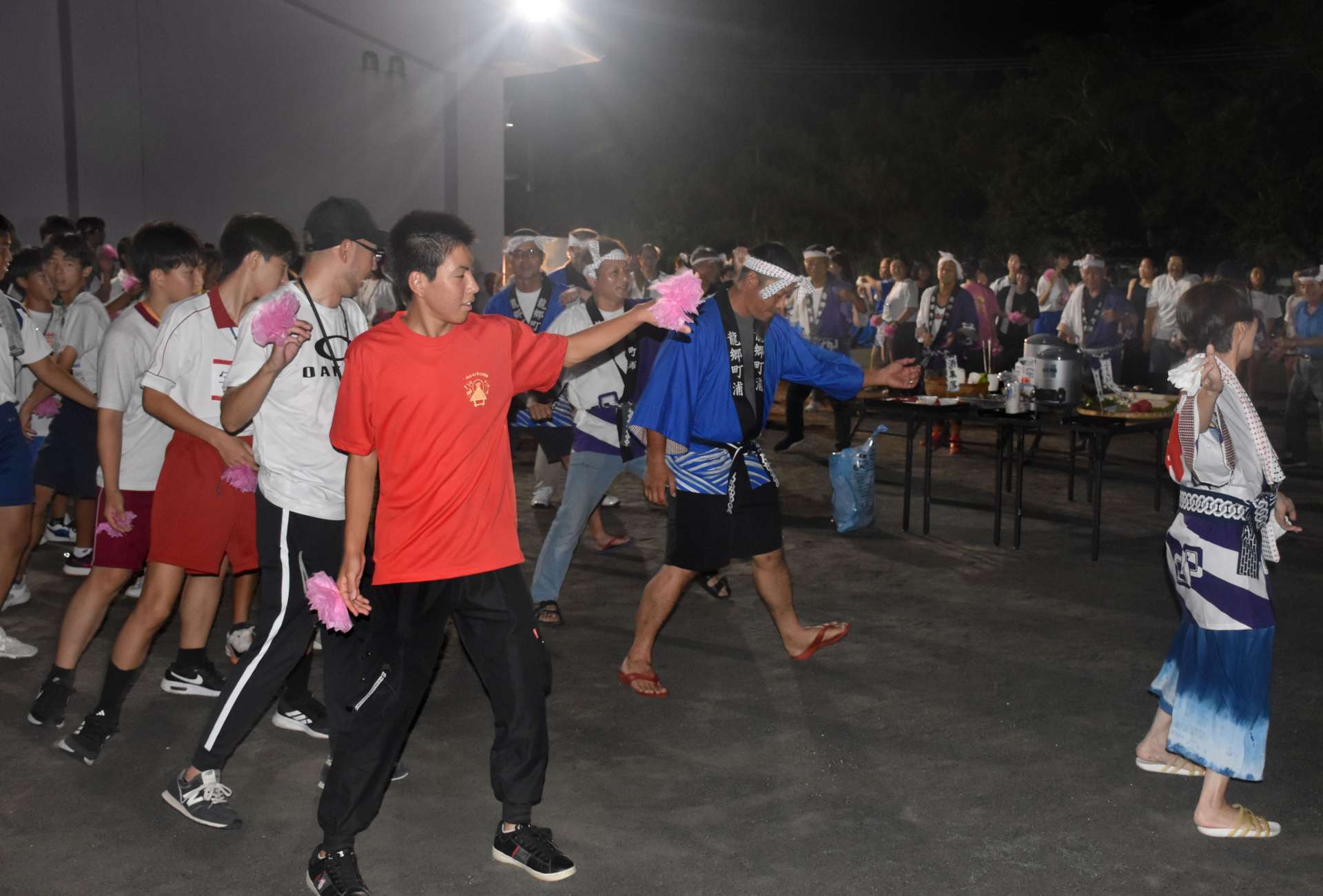 住民と一緒に八月踊りを踊る尼崎市の中学生ら＝龍郷町