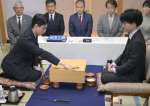 初手を打つ一力遼名人（左）。挑戦者は芝野虎丸十段＝２６日午前９時、鹿児島市の城山ホテル鹿児島