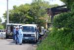 ⁮現場検証のため焼けた家に集まった警察官や消防士ら＝２６日午前１０時１５分、長島町蔵之元