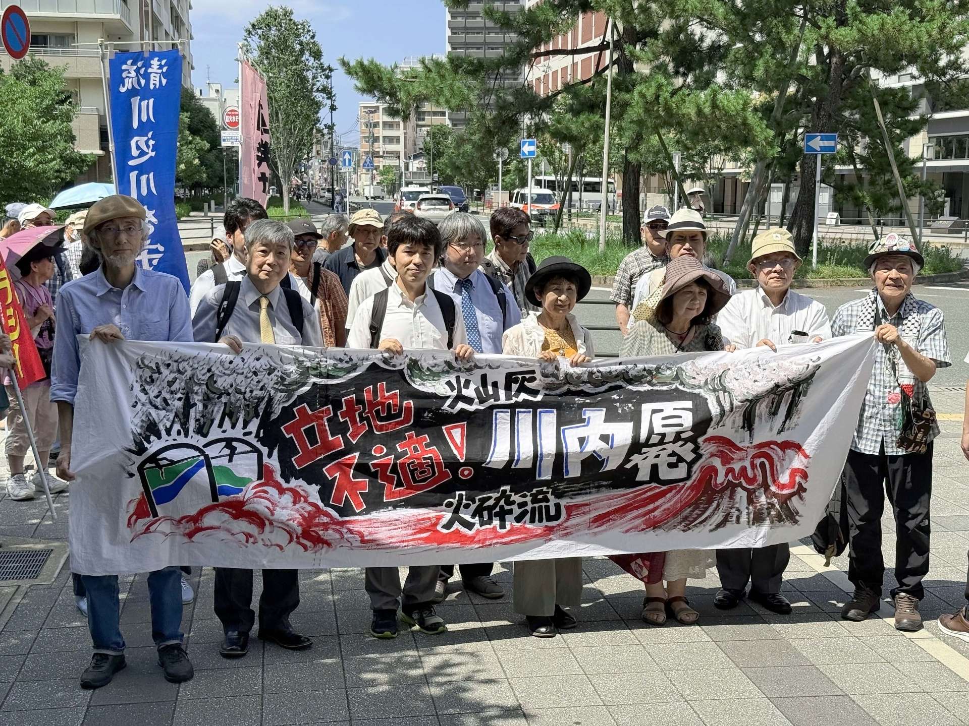 横断幕を手に福岡高裁に向かう原告ら＝２７日、福岡市