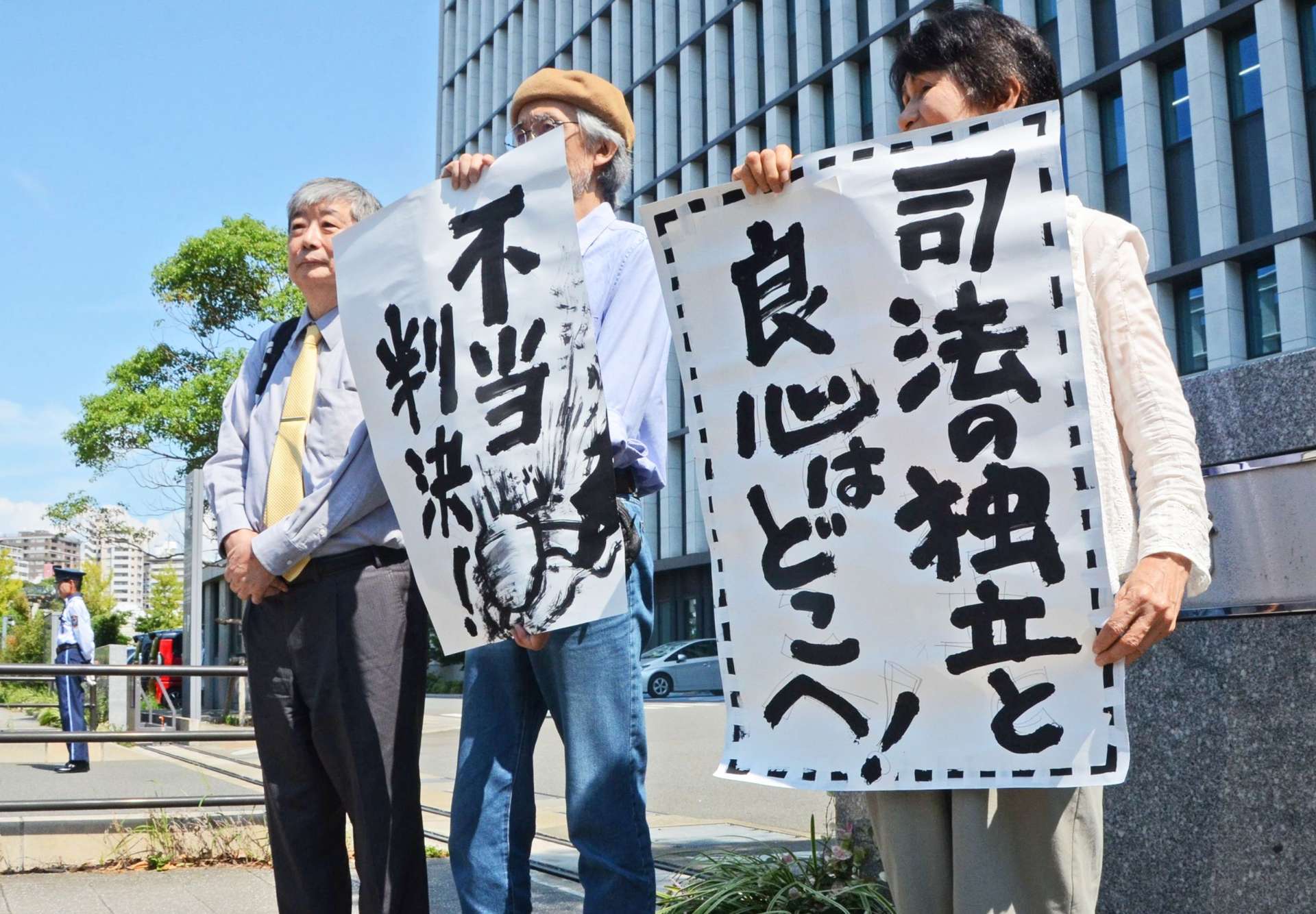 「不当判決」と書いた紙を掲げる原告ら＝２７日、福岡市の福岡高裁